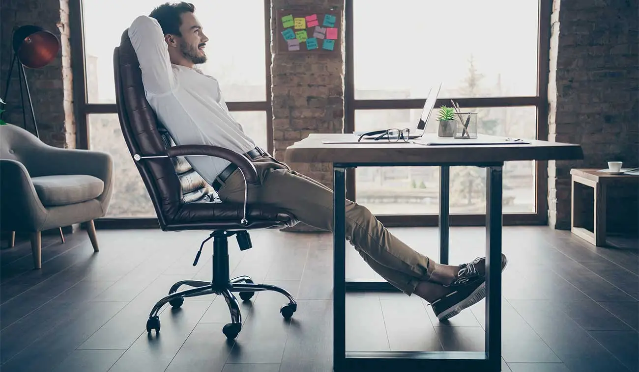 Hombre comodo con la elección correcta de su tipo de escritorio para trabajar