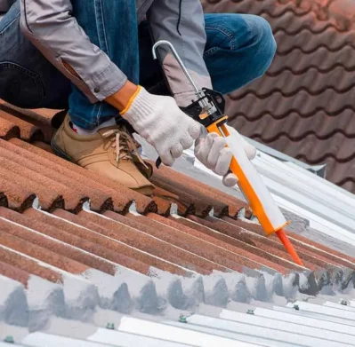 Especialista profesional aplicando sellador e impermeabilizador en techo de un hogar
