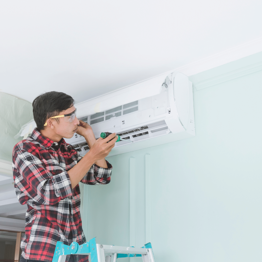 Experto realizando un mantenimiento al aire acondicionado