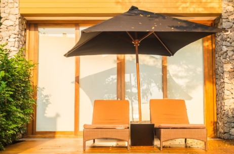 Instalación de parasol en terraza de hogar en Bogotá, con sillas reclinables y estructura de madera