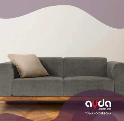 Cómo limpiar un sofá de tela gris con cojín beige y estructura de bambú para conservarlo en buen estado.